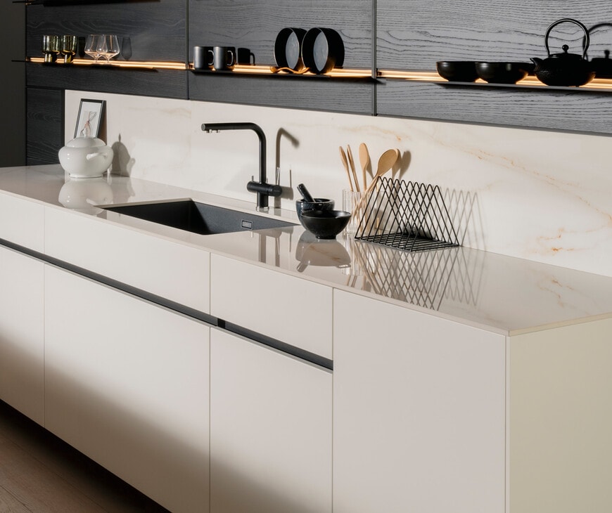 All-white Cucina kitchen with marble backsplash and black sink